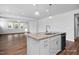 Kitchen island with stone countertop, stainless steel sink, and modern pendant lighting at 440 Golden Dragonfly St, Wake Forest, NC 27587