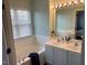 Bathroom with double sinks, shower tub, and a sunlit window, creating a refreshing ambiance at 4910 Briarstone Ct, Raleigh, NC 27610