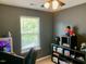 Cozy bedroom with a large window, gaming PC, and stylish Star Wars themed decor on the shelving at 4910 Briarstone Ct, Raleigh, NC 27610
