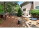 Wooded backyard with trees, playhouse, trampoline, patio, and lush greenery at 513 Commons Dr, Holly Springs, NC 27540