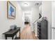 Inviting hallway with hardwood floors, neutral walls, and decoratively adorned table, leading to the living area and staircase at 513 Commons Dr, Holly Springs, NC 27540