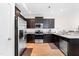 Modern kitchen with dark cabinetry, stainless steel appliances, granite countertops, and hardwood flooring for a modern look at 513 Commons Dr, Holly Springs, NC 27540