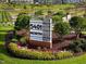 Community sign surrounded by lush landscaping and colorful flower beds at 5217 Beckom St, Raleigh, NC 27616