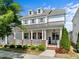 Charming two-story home boasting a welcoming front porch, white siding, dormer windows, and manicured landscaping at 5217 Beckom St, Raleigh, NC 27616