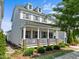 Beautiful white two-story house featuring a cozy front porch with swing, well-maintained lawn, and lovely curb appeal at 5217 Beckom St, Raleigh, NC 27616