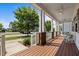 Spacious front porch with a wooden floor, ceiling fans, brick accents, and rocking chairs for relaxing outdoors at 5217 Beckom St, Raleigh, NC 27616