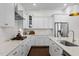Well-lit kitchen showcases white cabinets, stone countertops, and stainless steel appliances at 5217 Beckom St, Raleigh, NC 27616