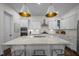 Bright, modern kitchen with white cabinetry, a large center island, stainless steel appliances, and stylish pendant lighting at 5217 Beckom St, Raleigh, NC 27616