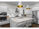 Modern kitchen features white cabinets, stainless steel appliances, and a large center island with seating at 5217 Beckom St, Raleigh, NC 27616