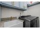 This laundry room boasts blue cabinets with gold handles, granite countertops, and modern appliances at 5217 Beckom St, Raleigh, NC 27616
