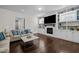 Comfortable living room featuring a fireplace, built-in shelving, dark hardwood floors, and lots of natural light at 5217 Beckom St, Raleigh, NC 27616