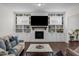 Cozy living area with a brick fireplace, built-in shelves, hardwood floors, and stylish furniture for relaxation at 5217 Beckom St, Raleigh, NC 27616