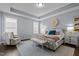 Serene main bedroom features a tray ceiling, ample natural light, and a cozy sitting area at 5217 Beckom St, Raleigh, NC 27616
