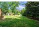 Lush backyard with trees, green grass, and a wooden playground at 5346 Deep River Rd, Sanford, NC 27330