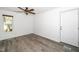 Bright bedroom with a ceiling fan, a window view, neutral wall paint, and wood-look flooring at 5346 Deep River Rd, Sanford, NC 27330