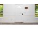Bright entryway featuring a white door with a decorative window, light gray walls, and two windows at 5346 Deep River Rd, Sanford, NC 27330