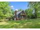 Quaint house with a brick chimney and a wrap-around porch set on a well-manicured lawn at 5346 Deep River Rd, Sanford, NC 27330