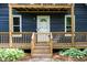 Close-up of the front porch with wooden steps and white trim, leading to a white front door at 5346 Deep River Rd, Sanford, NC 27330