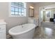 Bright bathroom featuring a soaking tub, large window, and a vanity with ample counter space at 536 Adkins Ridge Rd, Rolesville, NC 27571