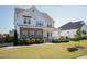 Inviting two-story home with stone accents, a charming front porch, and lush landscaping on a sunny day at 536 Adkins Ridge Rd, Rolesville, NC 27571