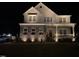 Night view of a two-story home with stone accents, inviting porch, and professionally illuminated landscaping at 536 Adkins Ridge Rd, Rolesville, NC 27571