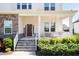 Welcoming front porch with swing, rocking chairs, stone accents, and lush landscaping at 536 Adkins Ridge Rd, Rolesville, NC 27571