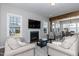 Inviting living room with a fireplace, TV, plush seating, and bright windows with views of the backyard at 536 Adkins Ridge Rd, Rolesville, NC 27571