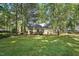 Large backyard features a lush lawn, mature trees, and the rear facade of the house at 5414 Stanley Rd, Durham, NC 27704