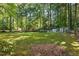Lawn with mature trees with home outbuilding with fencing at 5414 Stanley Rd, Durham, NC 27704