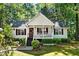 Charming one-story home with white siding, landscaped yard, and inviting front porch with railing at 5414 Stanley Rd, Durham, NC 27704