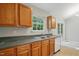 Kitchen featuring wood cabinets, window above sink, and a dishwasher at 5414 Stanley Rd, Durham, NC 27704