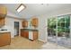 This bright kitchen features wood cabinets, a range oven, and a sliding glass door to a deck at 5414 Stanley Rd, Durham, NC 27704