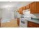 Kitchen featuring wood cabinets, stove, and view into a dining area at 5414 Stanley Rd, Durham, NC 27704