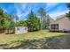 Large, grassy backyard featuring a storage shed and partial fence at 55 Fleming Forest Dr, Youngsville, NC 27596