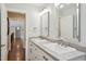 Bright bathroom featuring dual sinks with granite countertops, white cabinets, and modern lighting fixtures at 55 Fleming Forest Dr, Youngsville, NC 27596