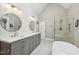 Bright bathroom featuring double sinks, gray cabinets, a soaking tub, and a stand-up shower at 55 Fleming Forest Dr, Youngsville, NC 27596