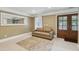 Cozy bedroom featuring a neutral color palette, large mirror, double glass doors, and a leather couch at 55 Fleming Forest Dr, Youngsville, NC 27596