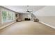 Expansive bonus room with neutral walls, neutral carpeting, and large windows offering views of the exterior at 55 Fleming Forest Dr, Youngsville, NC 27596