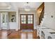 Stately foyer features a chandelier and staircase with wood floors and views of the stairs and front door at 55 Fleming Forest Dr, Youngsville, NC 27596