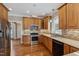 Well-lit kitchen featuring wooden cabinets, stainless steel appliances, granite countertops, and hardwood floors at 55 Fleming Forest Dr, Youngsville, NC 27596
