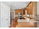 Charming kitchen showcasing granite countertops, wooden cabinets, and stainless steel appliances at 55 Fleming Forest Dr, Youngsville, NC 27596