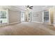 Bright primary bedroom with carpeted floors, ceiling fan, and large windows at 55 Fleming Forest Dr, Youngsville, NC 27596
