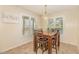 Bright dining area featuring a wooden table, pendant lighting, and natural light from surrounding windows at 5600 Sherrif W Pl, Raleigh, NC 27610