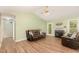 Cozy living room with a fireplace, wood flooring, and an open layout to other rooms at 5600 Sherrif W Pl, Raleigh, NC 27610