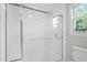 Bright bathroom featuring a white shower with glass doors and a window at 5612 Sandy Trail Dr, Knightdale, NC 27545
