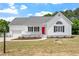 Charming home with white siding, black shutters, red front door and well-manicured landscaping at 5612 Sandy Trail Dr, Knightdale, NC 27545