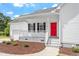 Cozy front porch with bright red door, white railings, and black shutters at 5612 Sandy Trail Dr, Knightdale, NC 27545