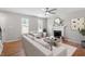 Bright living room featuring a ceiling fan, fireplace, and large windows for natural light at 5612 Sandy Trail Dr, Knightdale, NC 27545