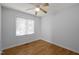 Simple, bright bedroom features hardwood floors, a ceiling fan, and a large window at 568 Piney Mountain Rd, Chapel Hill, NC 27514