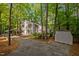 Shot showing the home's exterior, driveway, a carport, and a storage shed amidst lush trees at 568 Piney Mountain Rd, Chapel Hill, NC 27514